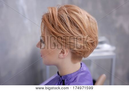 Young woman with trendy hairstyle at beauty salon