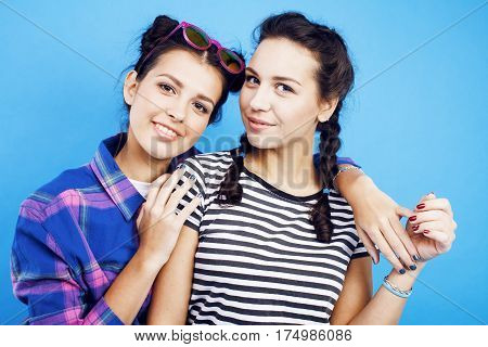 best friends teenage school girls together having fun, posing emotional on blue background, besties happy smiling, lifestyle people concept close up