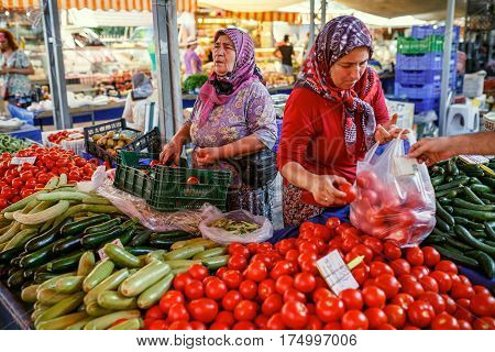 KEMER/ TURKEY - AUGUST 31, 2015. Muslim women selling the vegetables in the Turkish market. Kemer, Turkey.