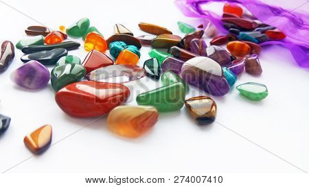 Assorted Natural Bright Coloured Semi Precious Gemstones And Gems In Bag On White Background
