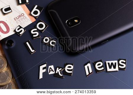 The Concept Of Mobility News: Tablet, Touch Phone, Money And Cutting From The Text With Letters