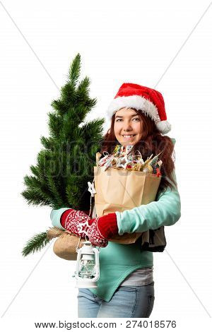 Photo Of Woman In Santa Hat With Christmas Tree, Paper Bag Inhands On Empty White Background