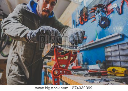 A Male Worker In A Ski Service Workshop Repairs The Sliding Surface Of The Skis. Close-up Of A Hand 