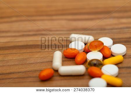 Many Bright Medicine Pills On Wooden Background. Cropped Shot, Horizontal, Side View. Concept Of Med