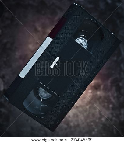 Levitation Video Cassette On The Background Of A Dark Concrete Wall. Mystical Light. Retro Technolog