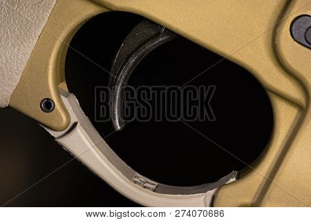Trigger On An Ar-15 In A Gold Color On A Dark Background