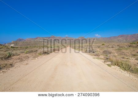 Straight Dirt Road In Cabo De Gata Natural Park With Mountains In Horizon (cabo De Gata In Spanish),