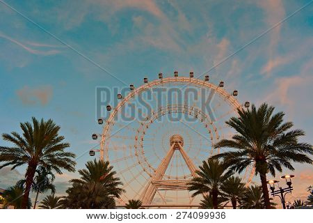 Orlando, Florida. October 18, 2018 . Orange Iluminated Big Wheel  On Cloudy Lightblue Background In 