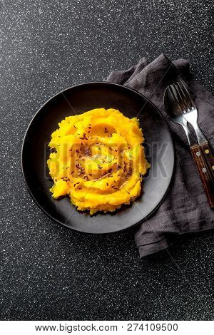 Mashed Potato With Pumpkin In Black Bowl. Dark Background. Top View