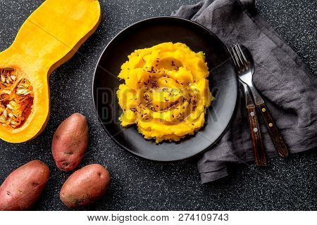 Mashed Potato With Pumpkin In Black Bowl. Dark Background. Top View
