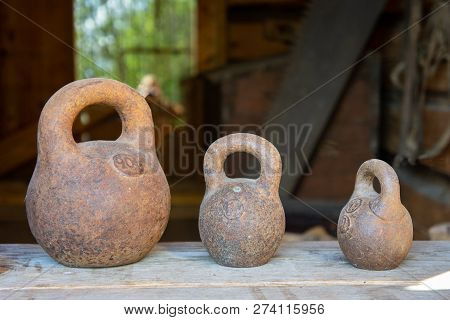 Three Small Calibration Weights Standing On Wooden Background