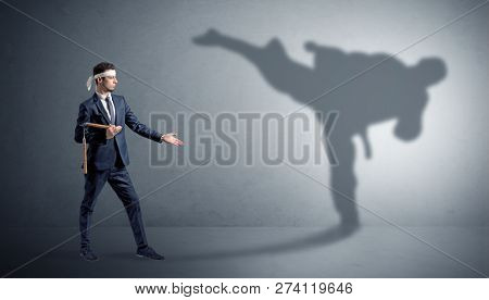 Young karate man confronting with his own shadow