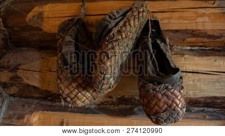 Old Bast Shoes. Traditional Russian Footwear. Shoes From The Bark Of The Tree.