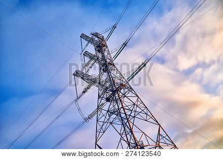 A Transmission Tower Or Electricity Pylon With Blue Sky. It Is A Tall Structure, Usually A Steel Lat