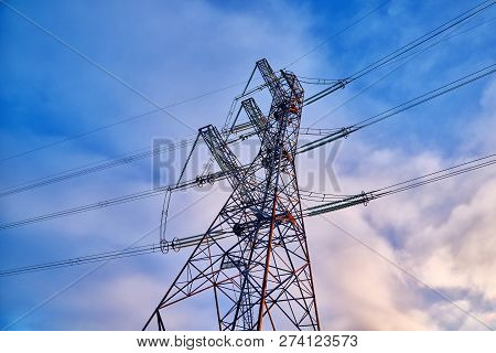 A Transmission Tower Or Electricity Pylon With Blue Sky. It Is A Tall Structure, Usually A Steel Lat
