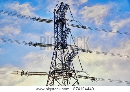 A Transmission Tower Or Electricity Pylon With Blue Sky. It Is A Tall Structure, Usually A Steel Lat