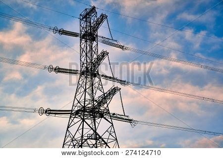 A Transmission Tower Or Electricity Pylon With Blue Sky. It Is A Tall Structure, Usually A Steel Lat
