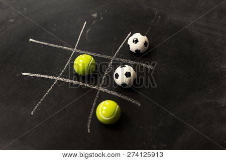 Tennis Vs Football Tic Tac Toe Game Competition. Challenge Concept On Black Chalk Board