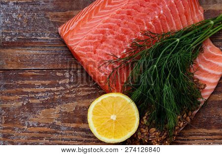 Fresh Salmon Closeup On Wooden Background With Lemon And Dill.
