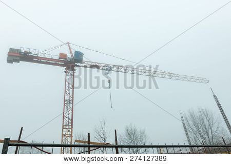 Tall Construction Crane In Fog Early Morning In City - Urban View