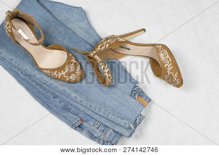 Fblue Jeans And Highheels Shoes With Embroidery Flatlay On A White Background