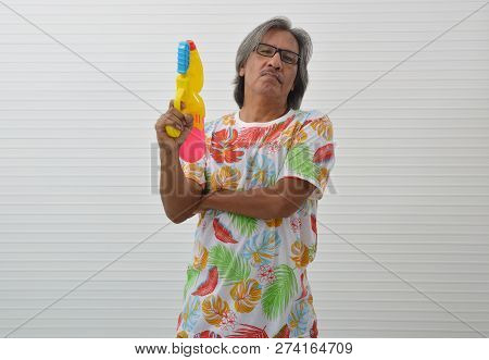 Happy Elderly Traveler Asian Man Wearing Summer Shirt And Sunglasses Holding Colorful Water Gun Over