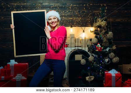 Christmas Eve. Christmas Woman Holding A Black Desk For Text. Black Board Copy Space. Christmas Prep