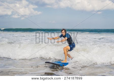 Young Man, Beginner Surfer Learns To Surf On A Sea Foam On The Bali Island