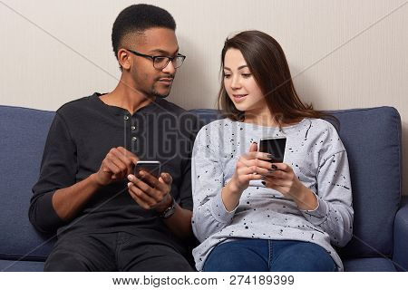 Photo Of Mixed Race People Update Application On Mobile Phones, Enjoys Spare Time With Modern Techno