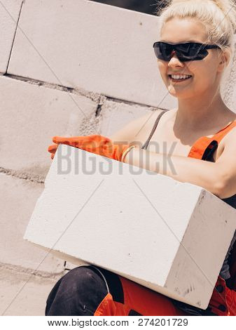 Strong Pretty Woman Working On Construction Site, Building House, Installing Gray Airbricks. Industr