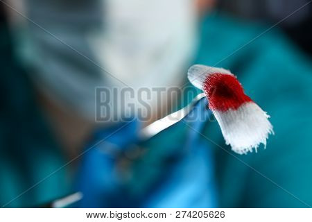 Surgeon In Sterile Uniform Arms Holding And Passing To Colleague Tools With Bio Material Wad Closeup