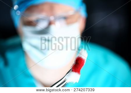 Surgeon In Sterile Uniform Arms Holding And Passing To Colleague Tools With Bio Material Wad Closeup