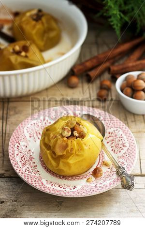 Baked Apples With Raisins, Hazelnuts And Cinnamon On Wooden Background. Rustic Style.