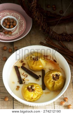 Baked Apples With Raisins, Hazelnuts And Cinnamon On Wooden Background. Rustic Style.