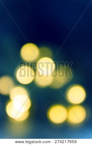 Background Of Blurry Blue-blue Lights Of The Christmas-tree Garland On The Dark. Copy Space.