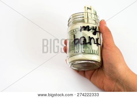 My Bank Written On A Jar In Hand With Dollar Banknotes. Savings And Home Finances Concept.