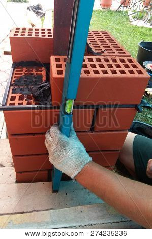 The Wizard Uses A Manual Level To Measure The Freshly Welded Wall
