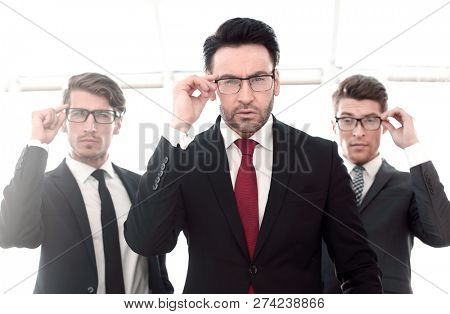 three businessmen with glasses, pretentious looking at the camera