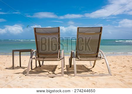 Two Chairs On The Shore Of The Warm Tropical Ocean
