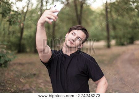 Close Up Portrait Of Attractive Young Caucasian Man With Dark Hair Making Selfie On Mobile Phone In 