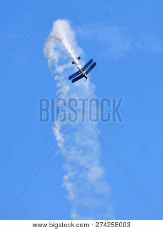 A By-plane Preforming Aerobatics With Smoke Trail.