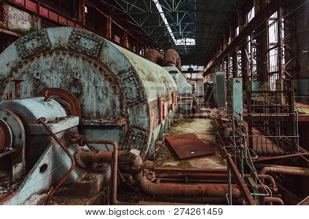 Rusty Turbine Generator. Abandoned Destroyed By War And Overgrown By Plants And Moss Machinery Of Tk
