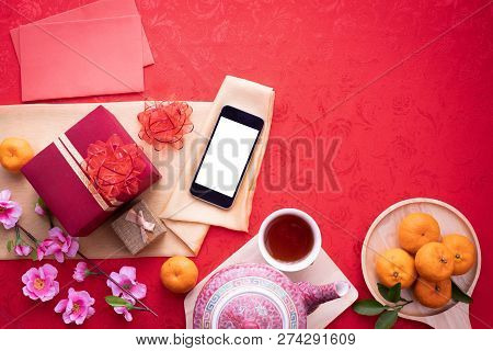 Blank Screen Smartphone With Chinese New Year Composition On Red Background. Copy Spcae. Top View.