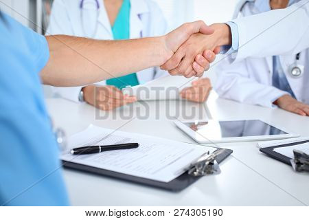 Two Doctors Shaking Hands To Each Other At Meeting. Teamwork And Agreement In Medicine
