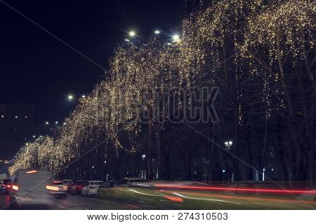 13 Dec 2018, Romania, Bucharest. Christmas Garland, Blurred Cars Lights And Traffic At Bulevardul Un