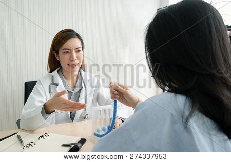 Female Doctor Explaining To Patient About To Use Incentive Spirometer