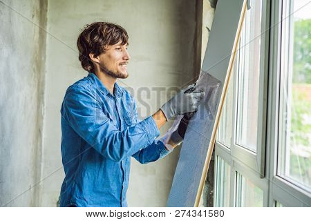 Man In A Blue Shirt Does Window Installation