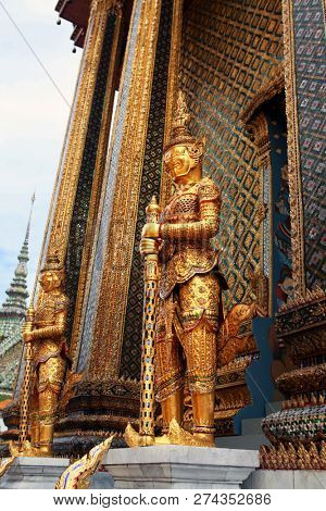 Statue of the golden guard at an entrance to the Phra Mondop temple