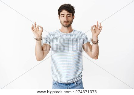 Meditation Keeps Mind Healthy. Portrait Of Good-looking Masculine, Fit Handsome Guy Raising Hands In