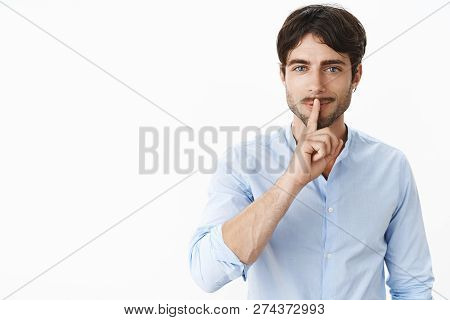 Waist-up Shot Of Sexy Handsome Successful Man With Beard And Blue Eyes Smiling Naughty Making Shush 